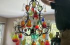 Repairing Colorful Chandelier In Dining Room With Ladder