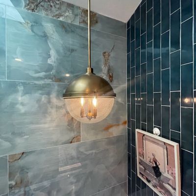 Bathroom Lighting With Blue Tiled Walls And Artwork