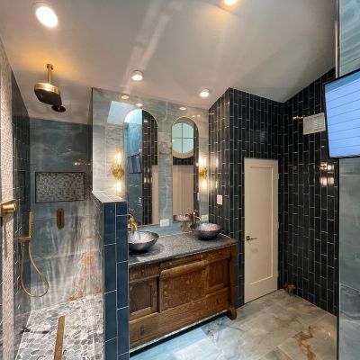 Modern Bathroom With Dark Tiles And Wooden Vanity And Mirrors