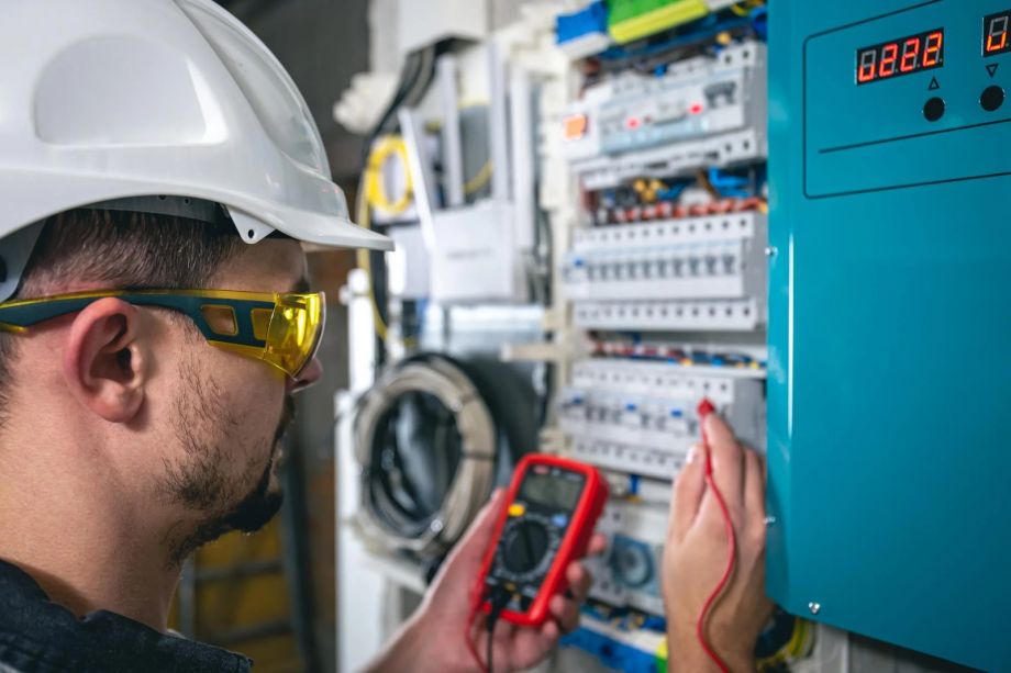 Electrician Testing Circuit With Multimeter In Industrial Setting