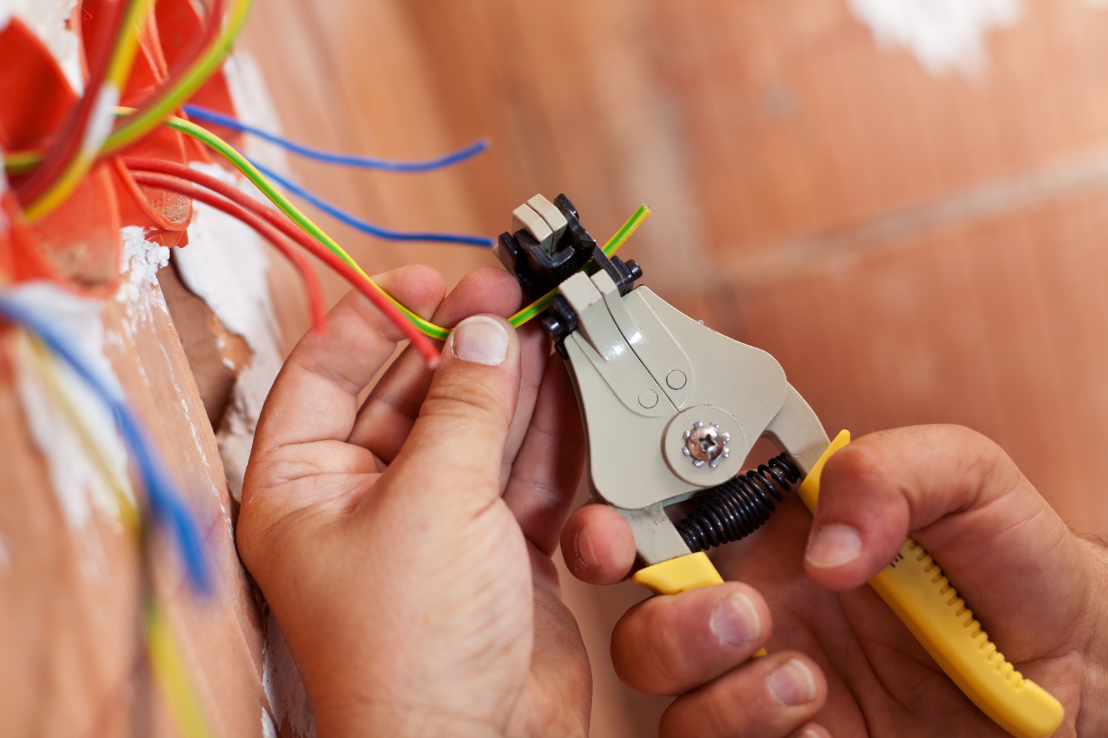 Electrician Using Wire Strippers On Cables In Wall Crofton Md