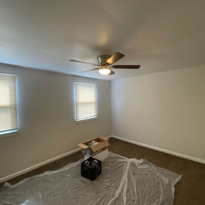 Empty Room With Blank Walls And Ceiling Fan And Box