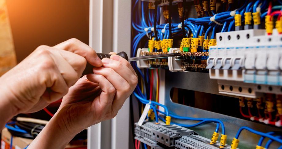 Electrical Panel Wiring Repair With Screwdriver In Hand