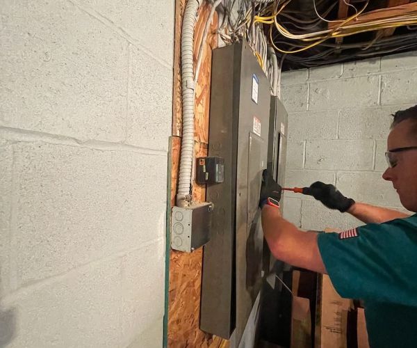 Electrician Working On Electric Panel In Basement Laurel Md