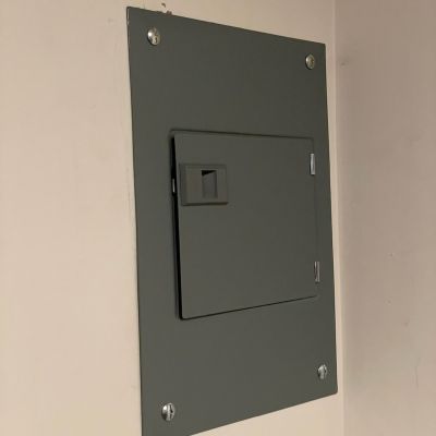 Gray Electrical Panel On Wall With Screws Closed