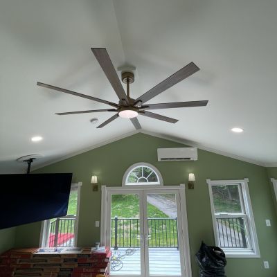 Living Room With Ceiling Fan And Green Walls And Doors Entrance