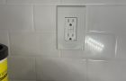 Wall Outlet On White Tile Background With Cleaning Supply