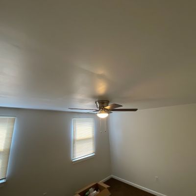 Ceiling Fan In A Light Room With Windows And Carpet